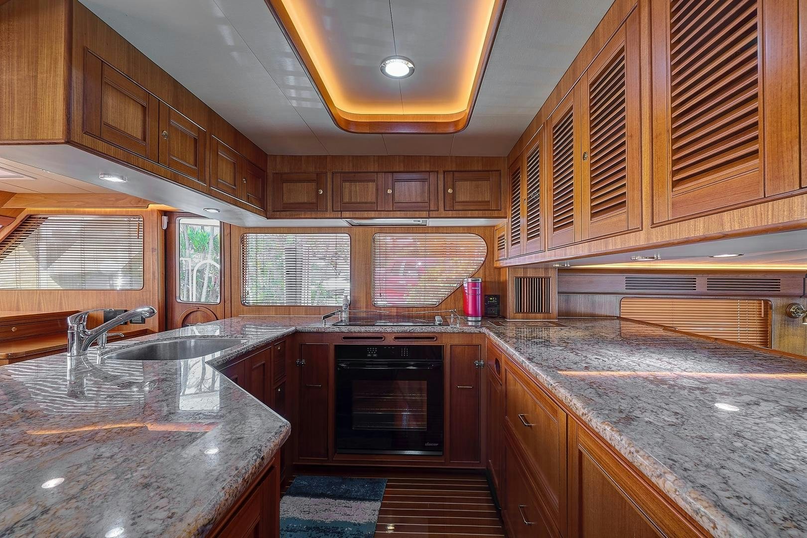 a kitchen with wooden cabinets aboard JOAN'S RONDEVOUS Yacht for Sale