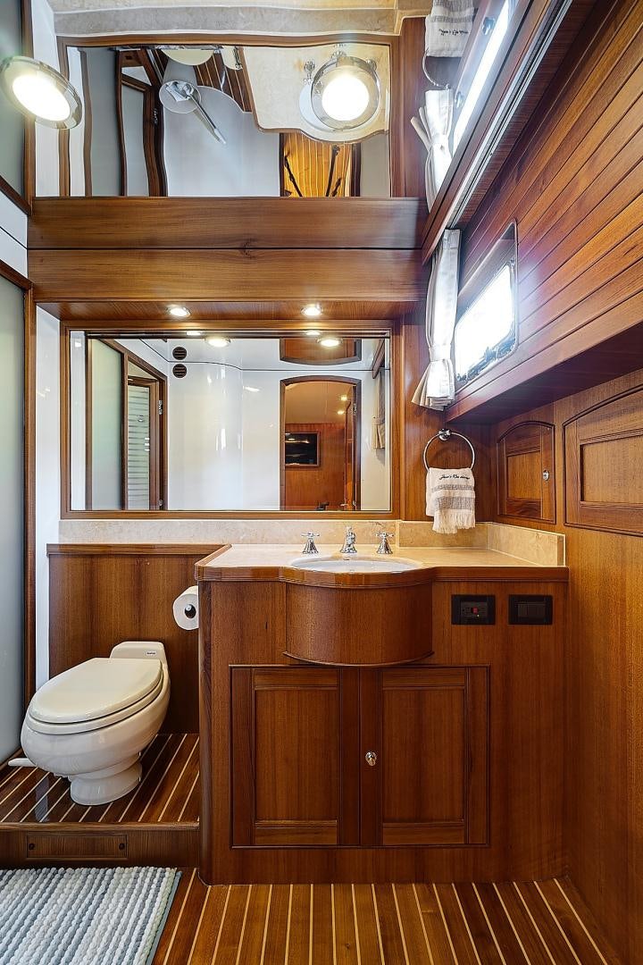 a bathroom with a sink toilet and a mirror aboard JOAN'S RONDEVOUS Yacht for Sale
