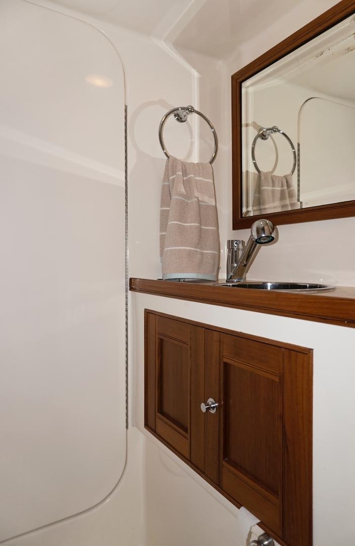 a bathroom with a mirror and a sink aboard JOAN'S RONDEVOUS Yacht for Sale