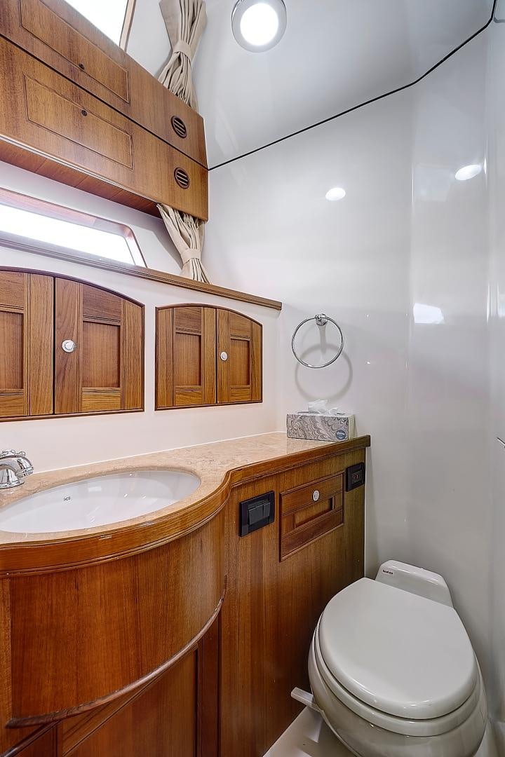 a bathroom with wooden cabinets aboard JOAN'S RONDEVOUS Yacht for Sale