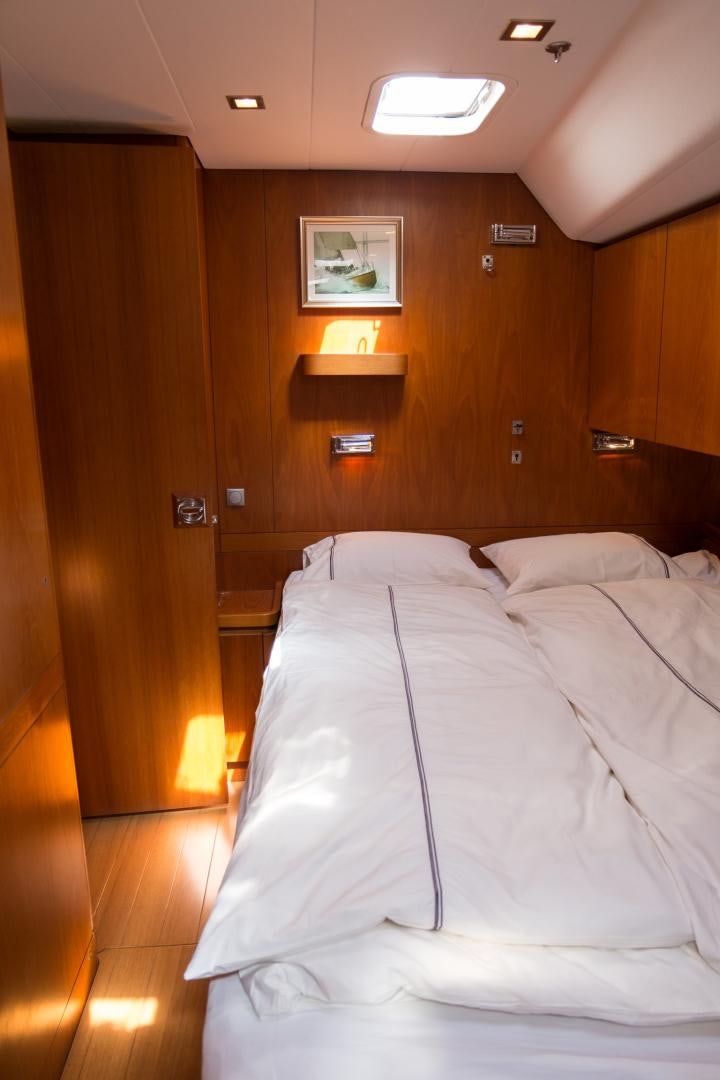a room with a bed and a wood door aboard enigma viii Yacht for Sale