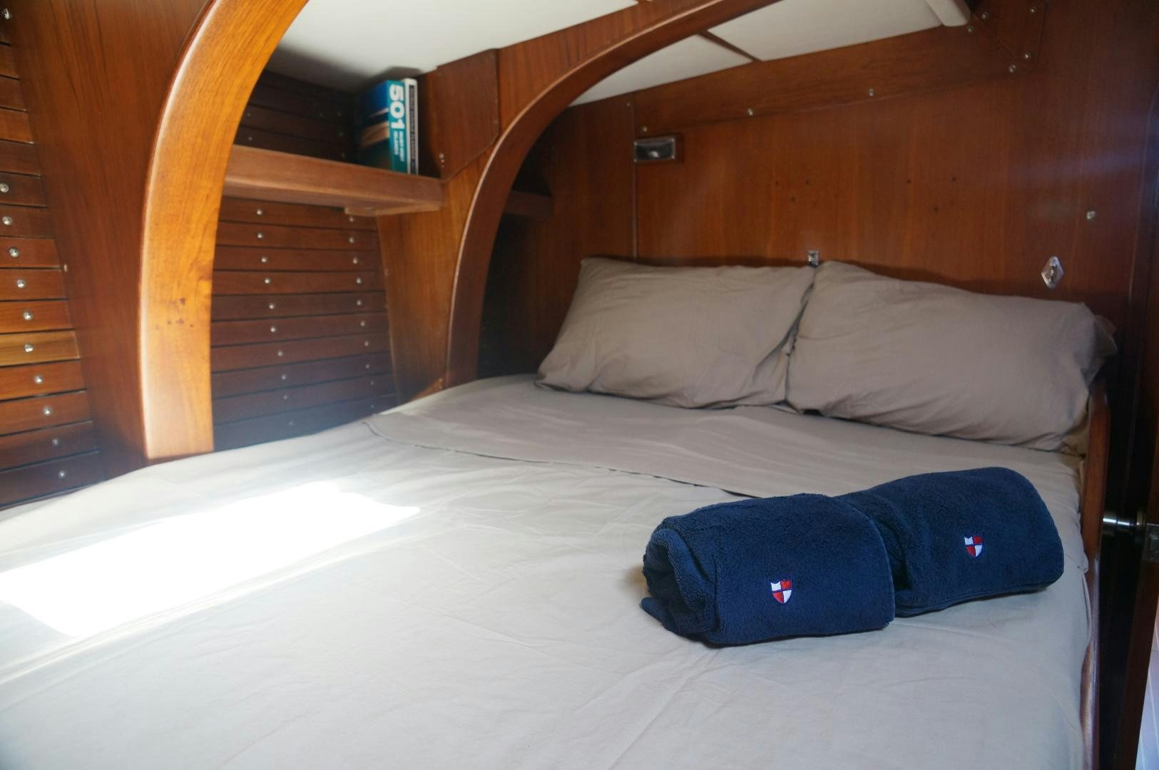 a bed with a blue blanket aboard kings legend Yacht for Sale