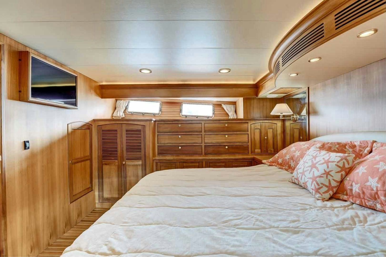 a bedroom with a bed and a wood cabinet aboard MEGUSTA Yacht for Sale