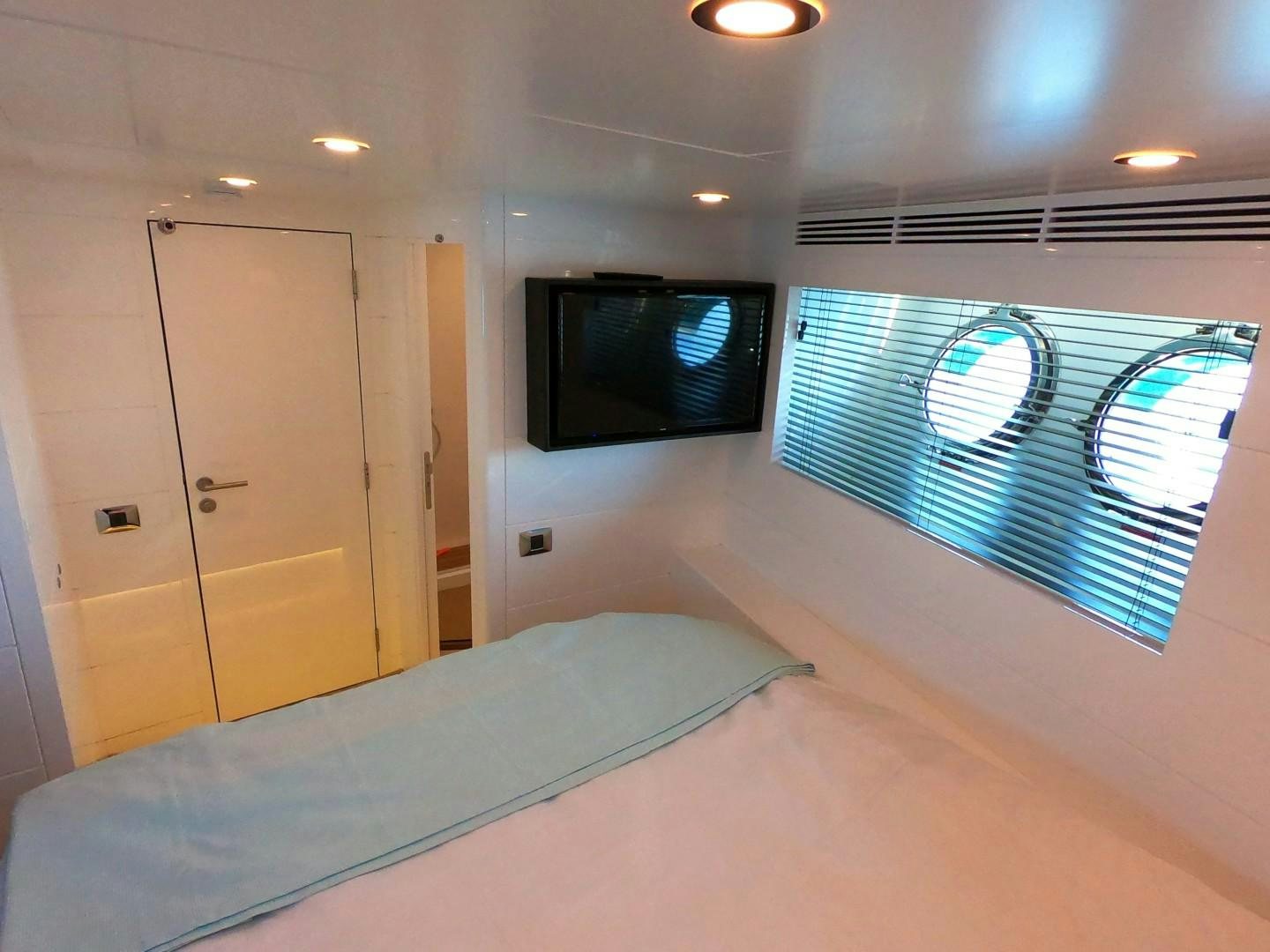 a room with a bed and a television aboard MUZO'S 20 Yacht for Sale