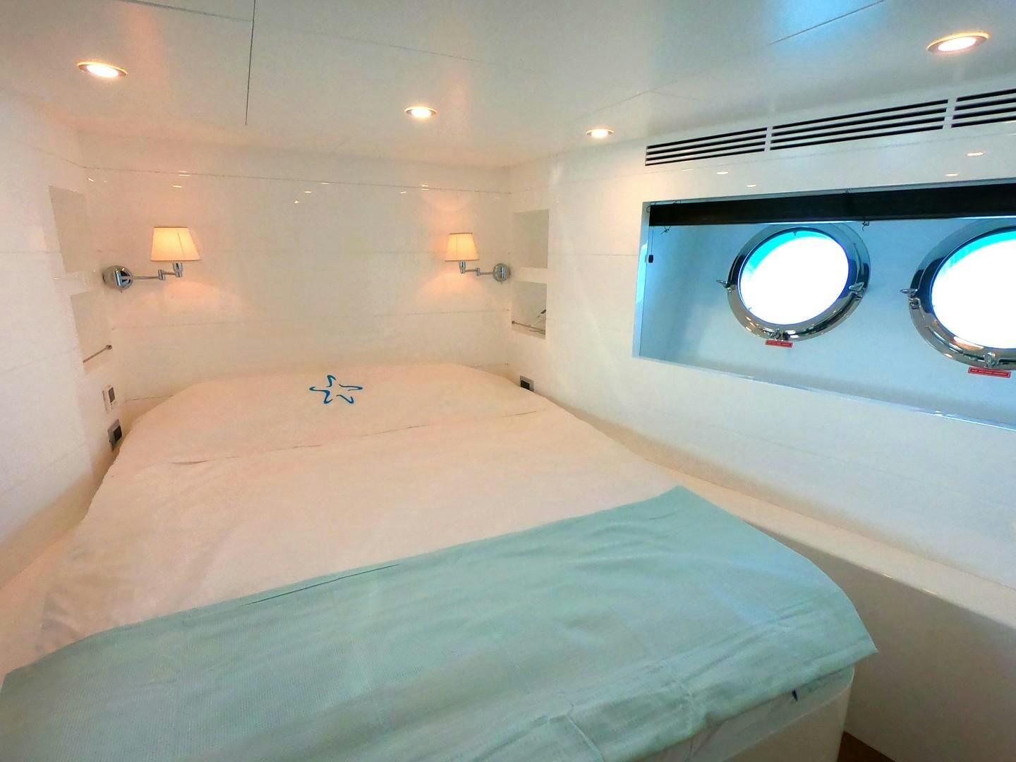 a bed with a round window aboard MUZO'S 20 Yacht for Sale