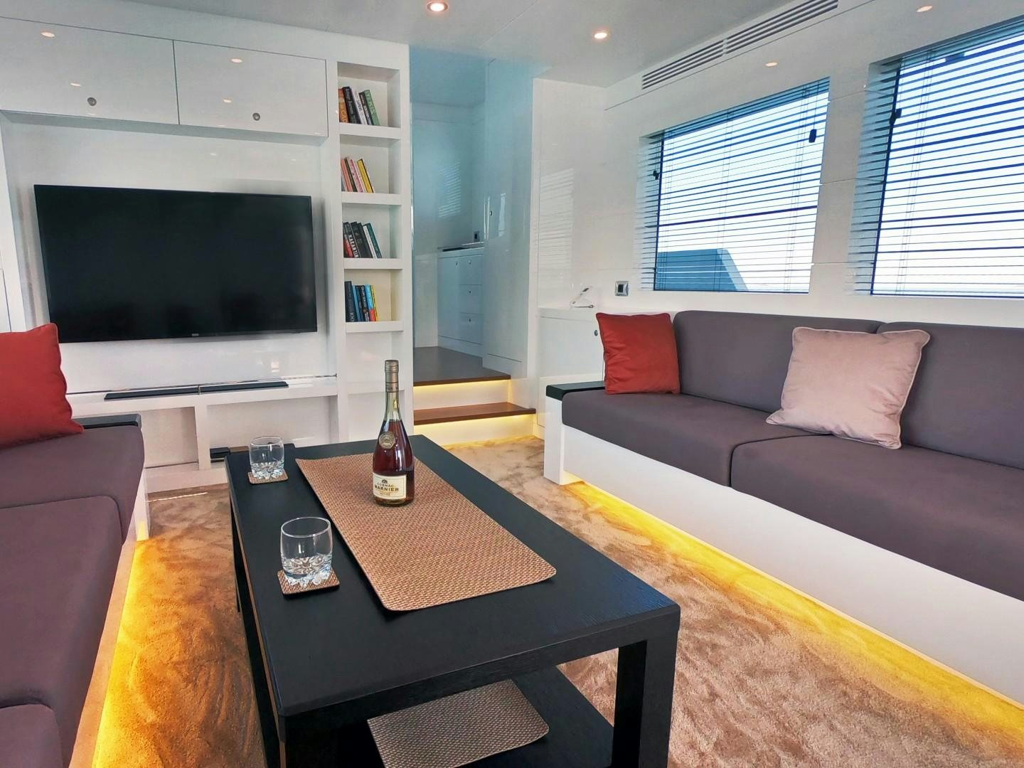 a living room with a table and a tv aboard MUZO'S 20 Yacht for Sale