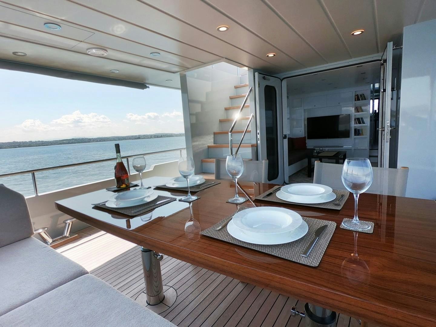 a table with wine glasses on it aboard MUZO'S 20 Yacht for Sale