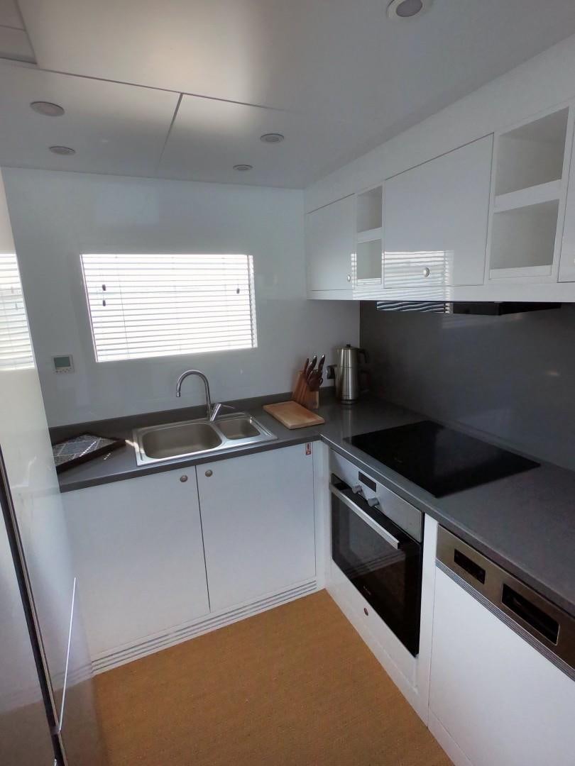 a kitchen with white cabinets aboard MUZO'S 20 Yacht for Sale