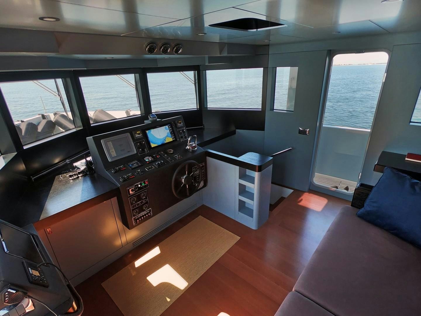 a room with a large window and a desk with a computer on it aboard MUZO'S 20 Yacht for Sale