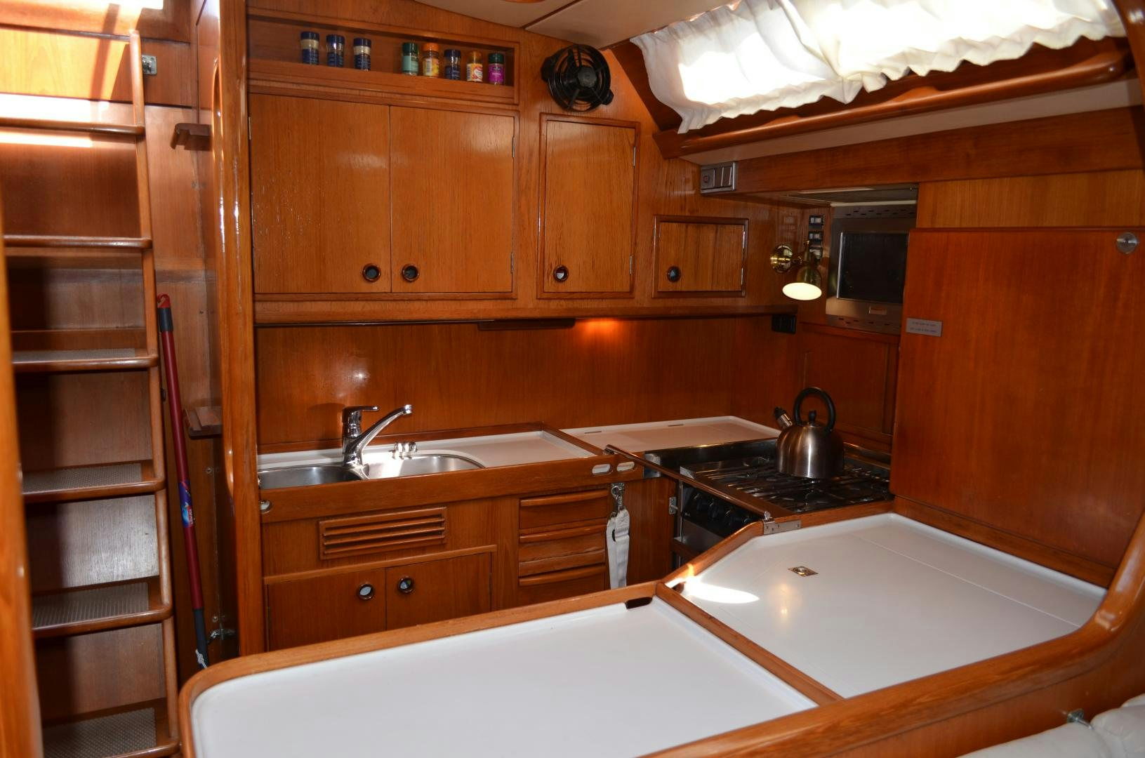 a kitchen with wooden cabinets aboard blue magic Yacht for Sale