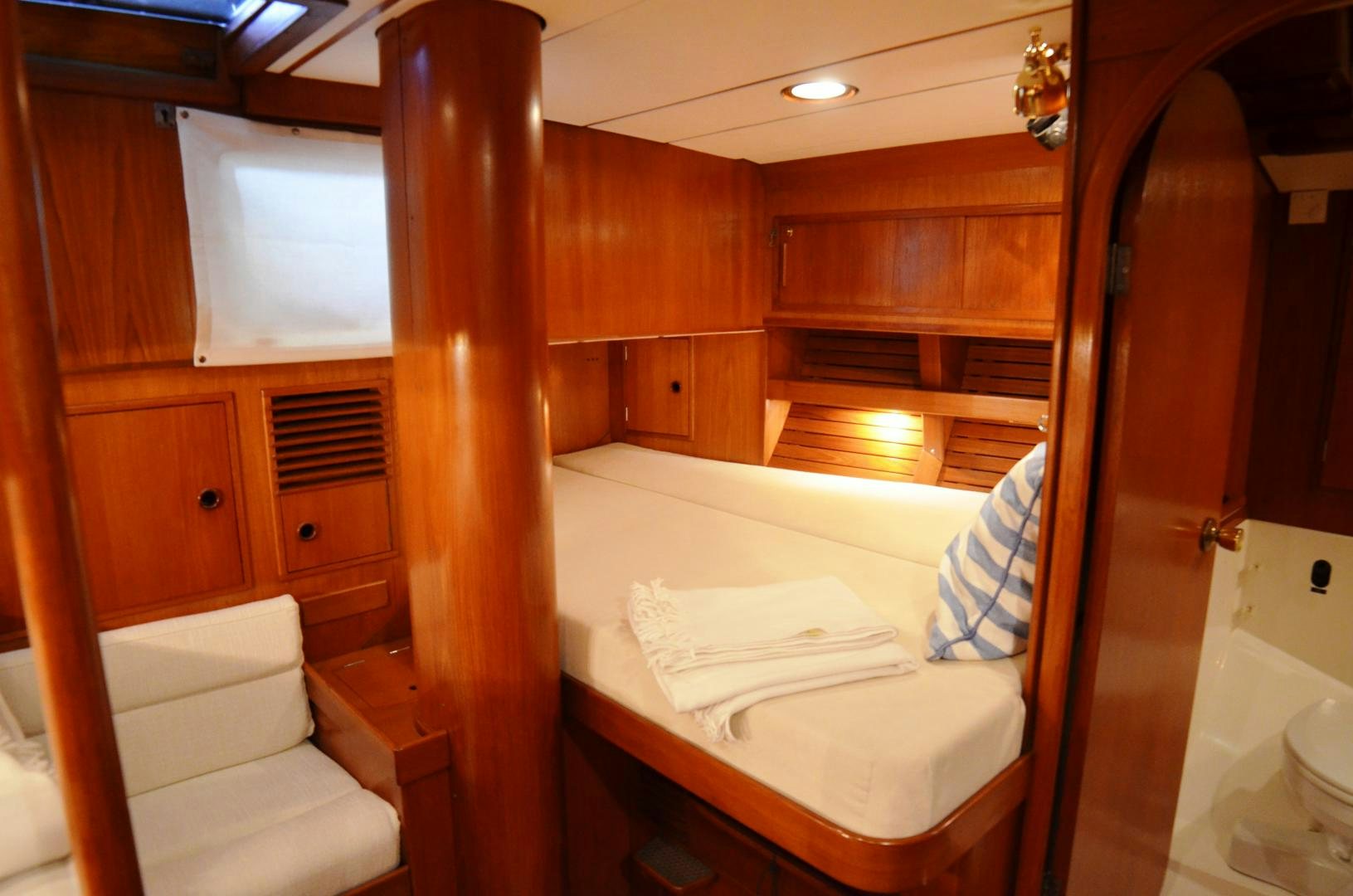 a room with a bed and a closet aboard blue magic Yacht for Sale
