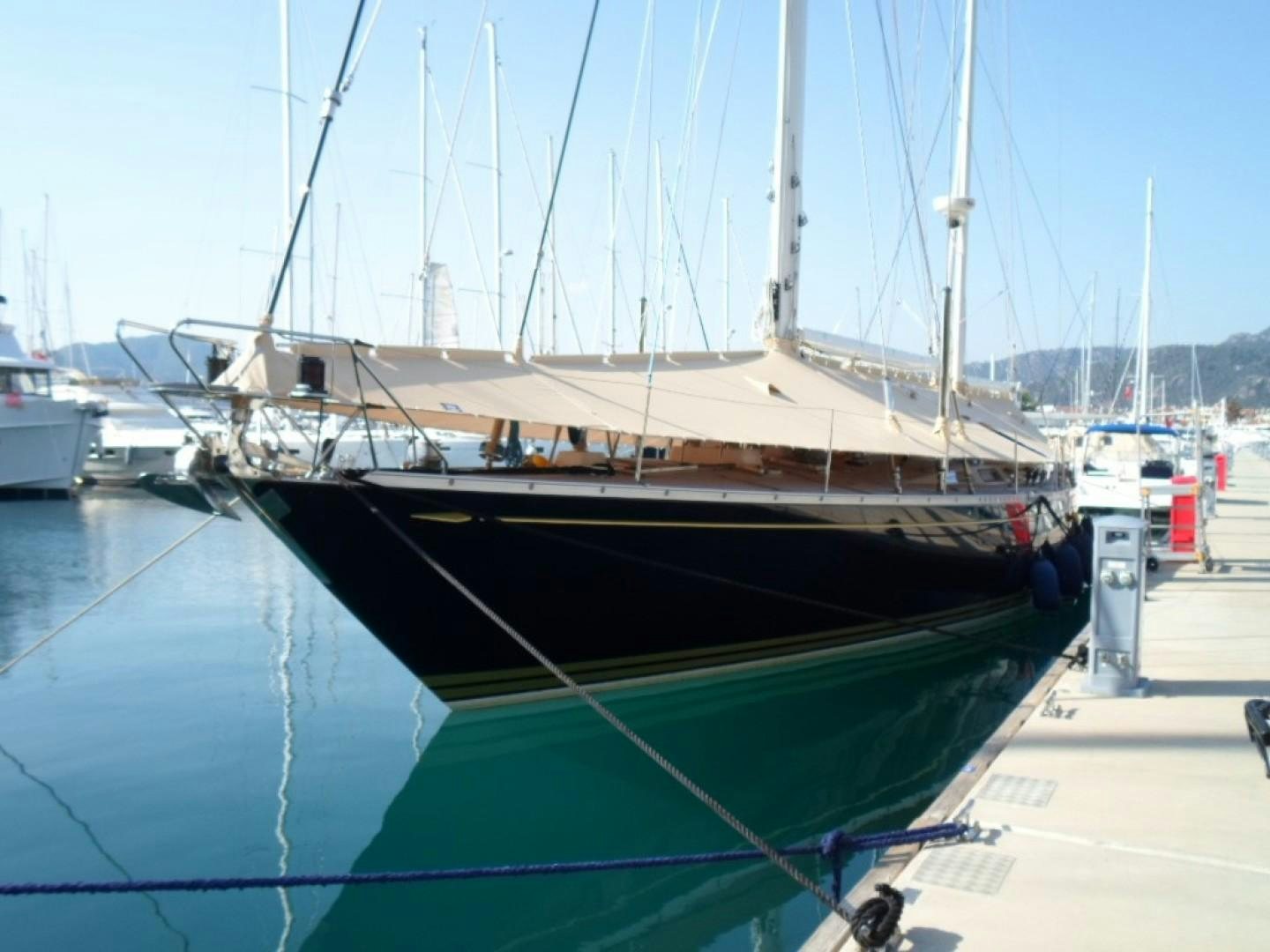 a boat docked at a pier aboard blue magic Yacht for Sale