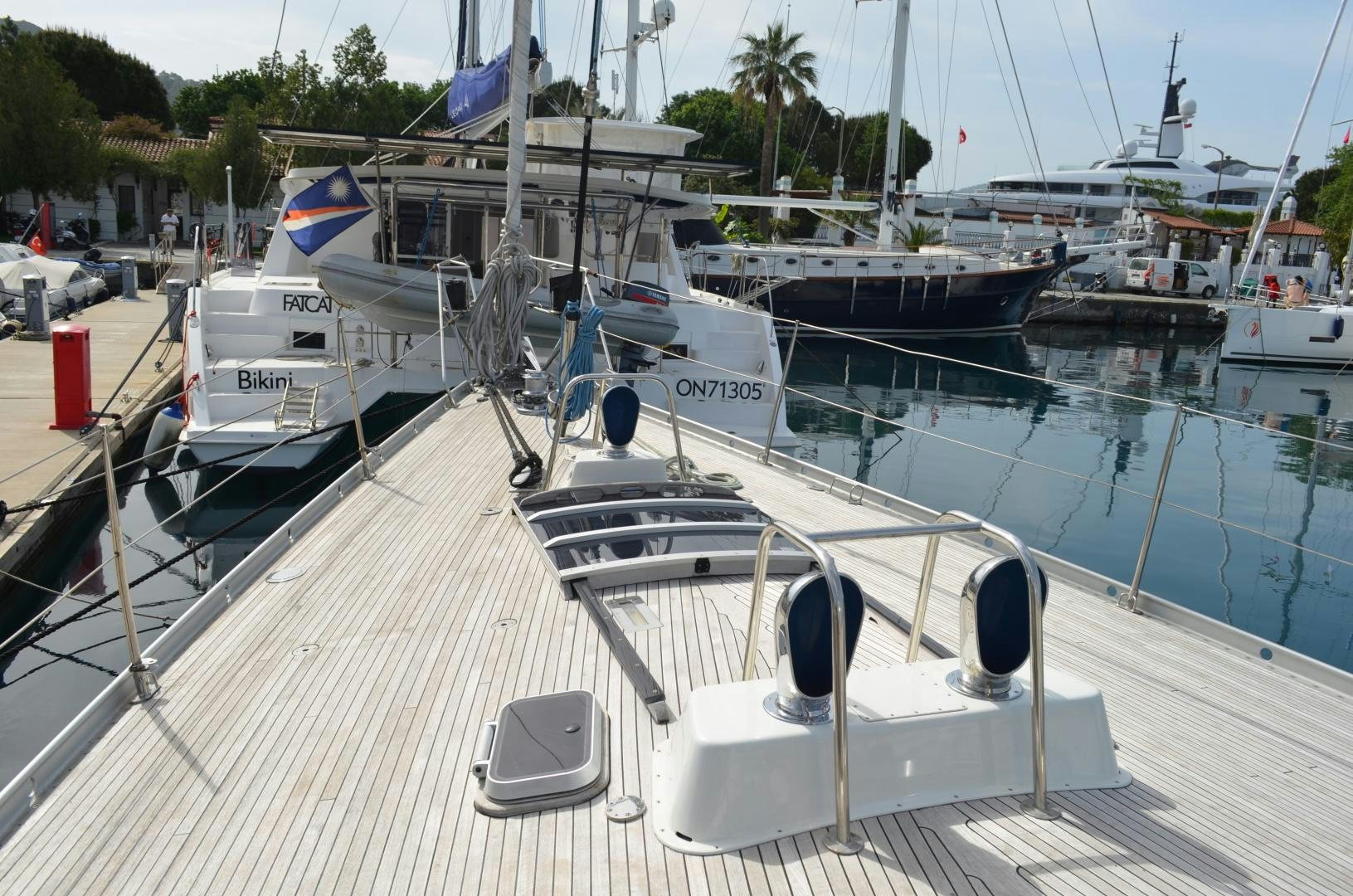 a boat docked at a pier aboard blue magic Yacht for Sale