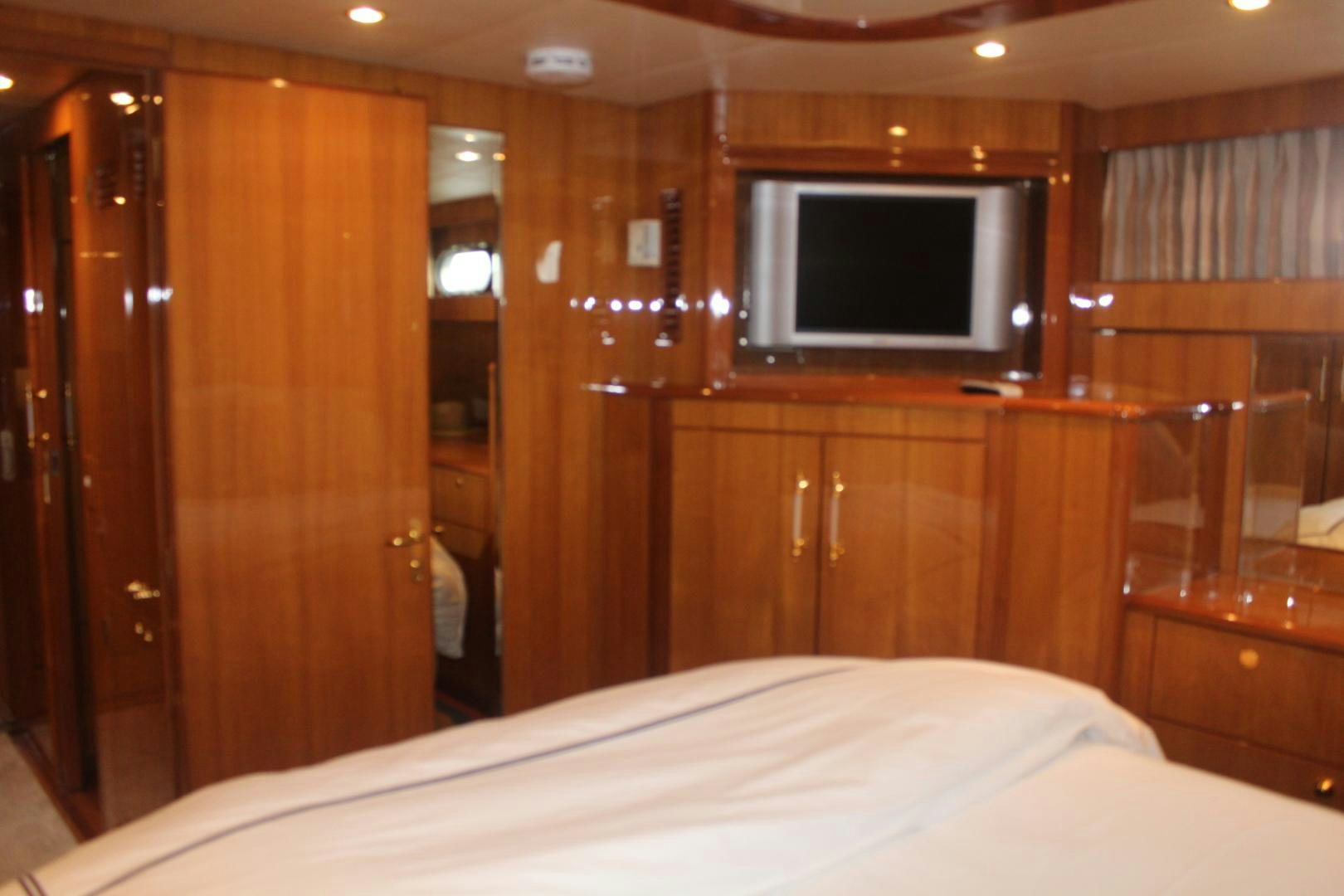 a bedroom with a bed and a television aboard LADY CYNTHIA Yacht for Sale