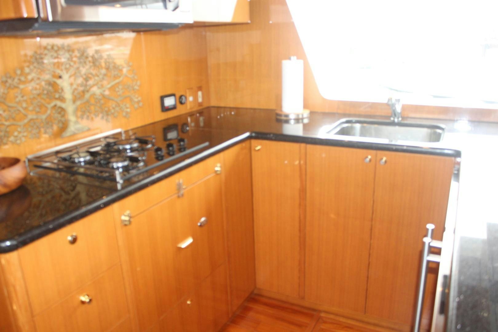 a kitchen with wooden cabinets aboard LADY CYNTHIA Yacht for Sale