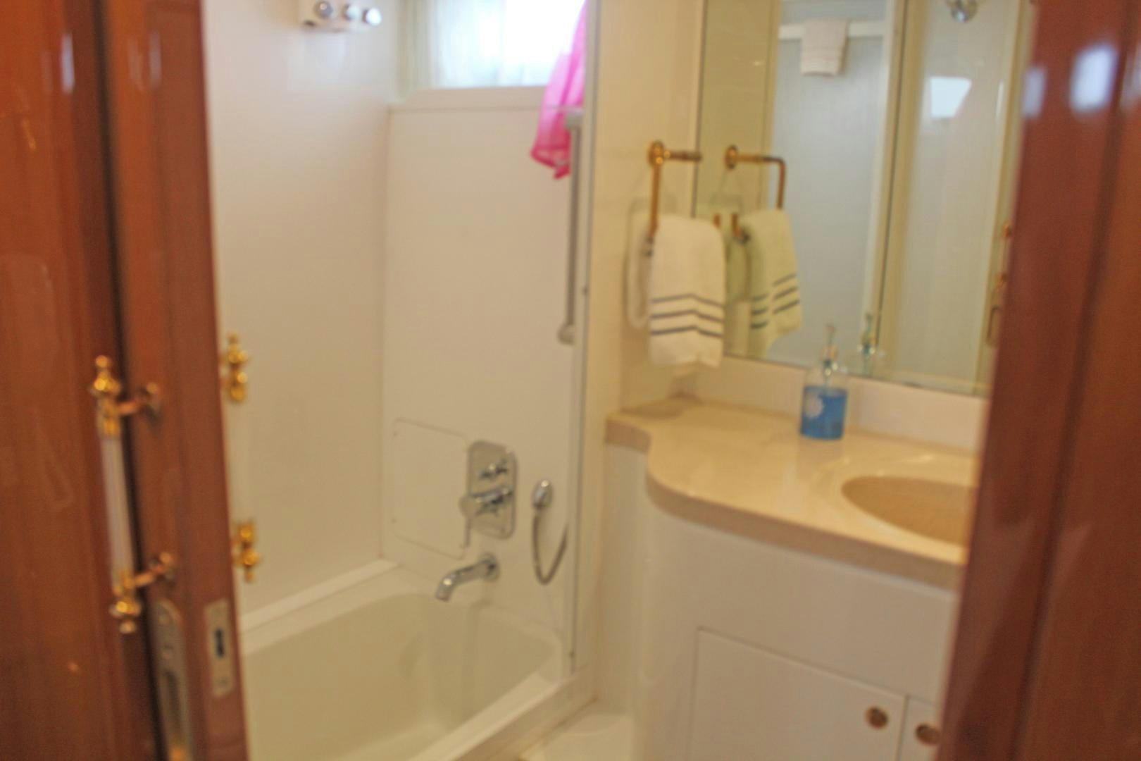 a bathroom with a bathtub and sink aboard LADY CYNTHIA Yacht for Sale