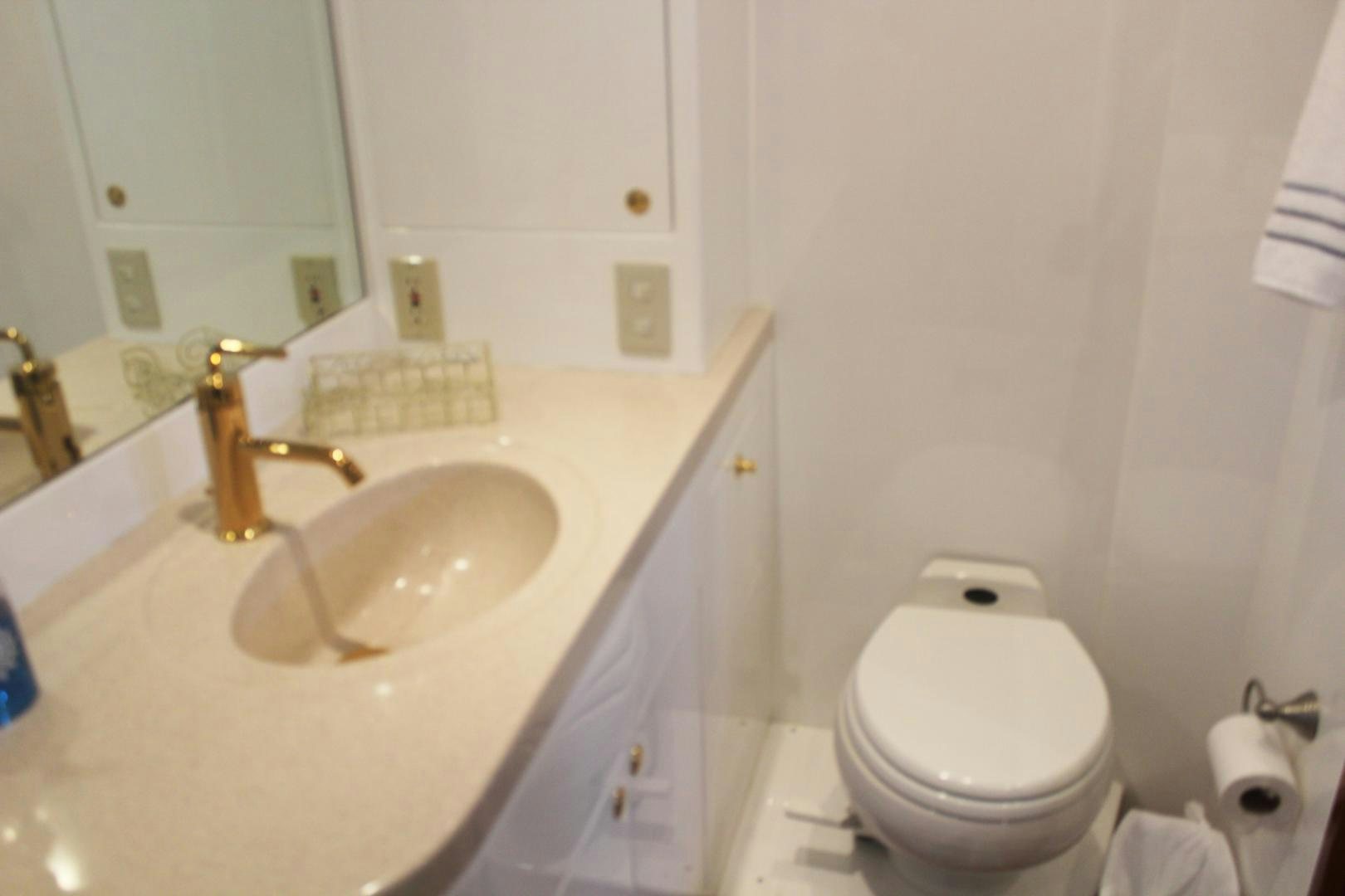 a bathroom with a toilet and sink aboard LADY CYNTHIA Yacht for Sale