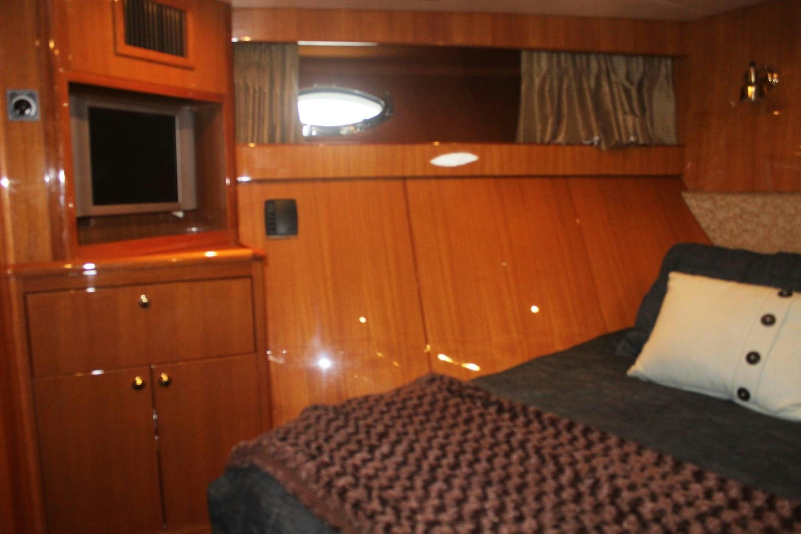 a bedroom with a bed and a television aboard LADY CYNTHIA Yacht for Sale