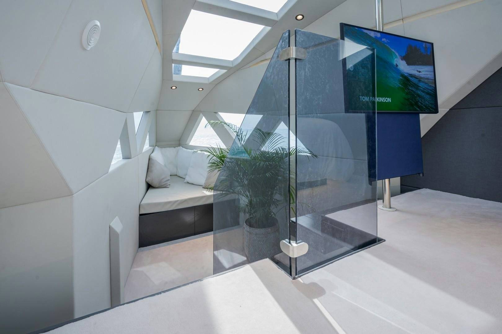 a room with a glass wall and a plant in a pot aboard X1 Yacht for Sale
