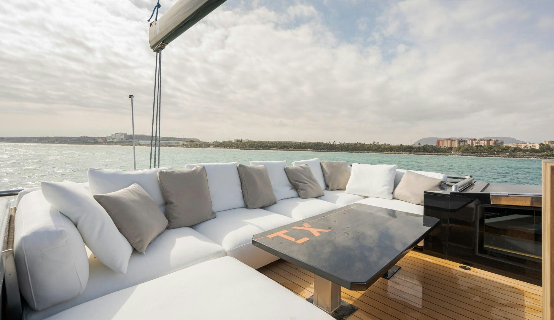 a couch with a table on it aboard X1 Yacht for Sale