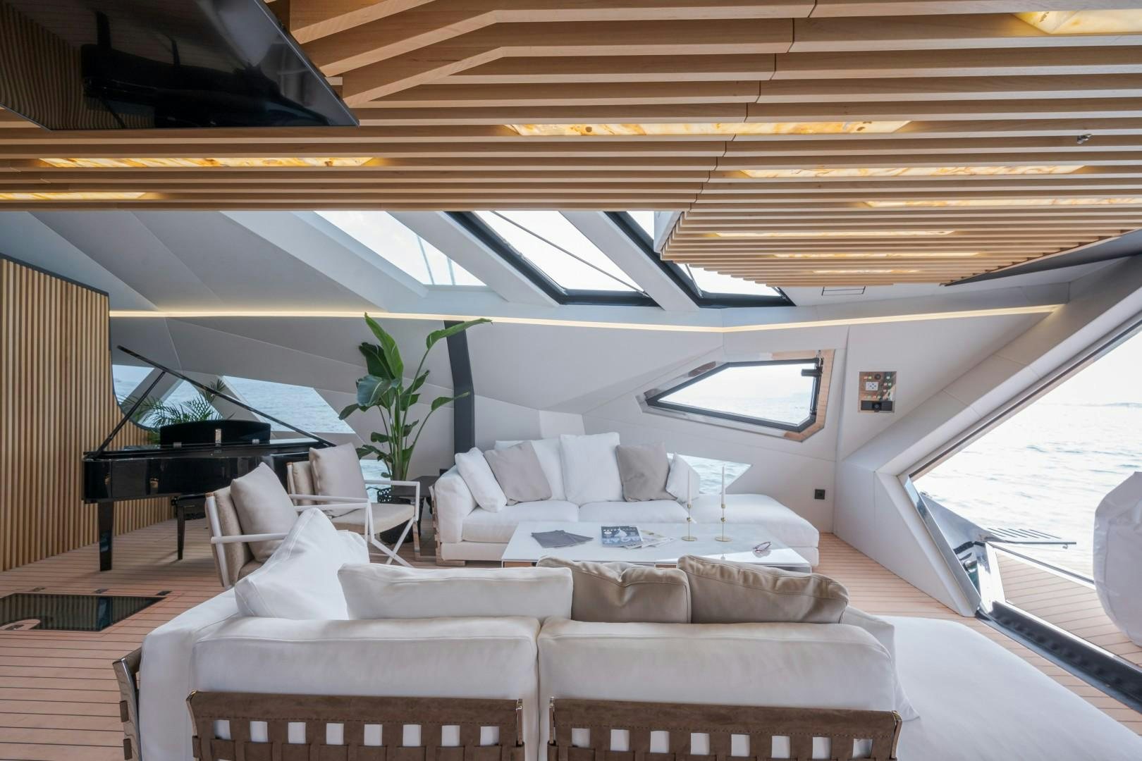 a room with couches and a piano aboard X1 Yacht for Sale