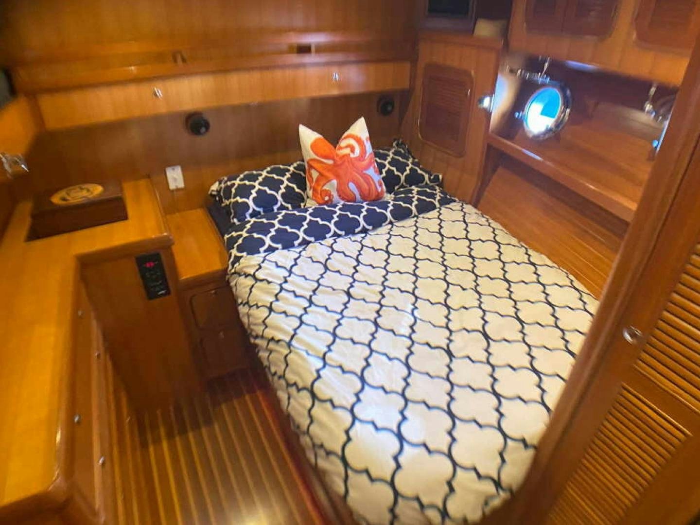 a bed with a blue and white blanket on it aboard RHINO 1 Yacht for Sale