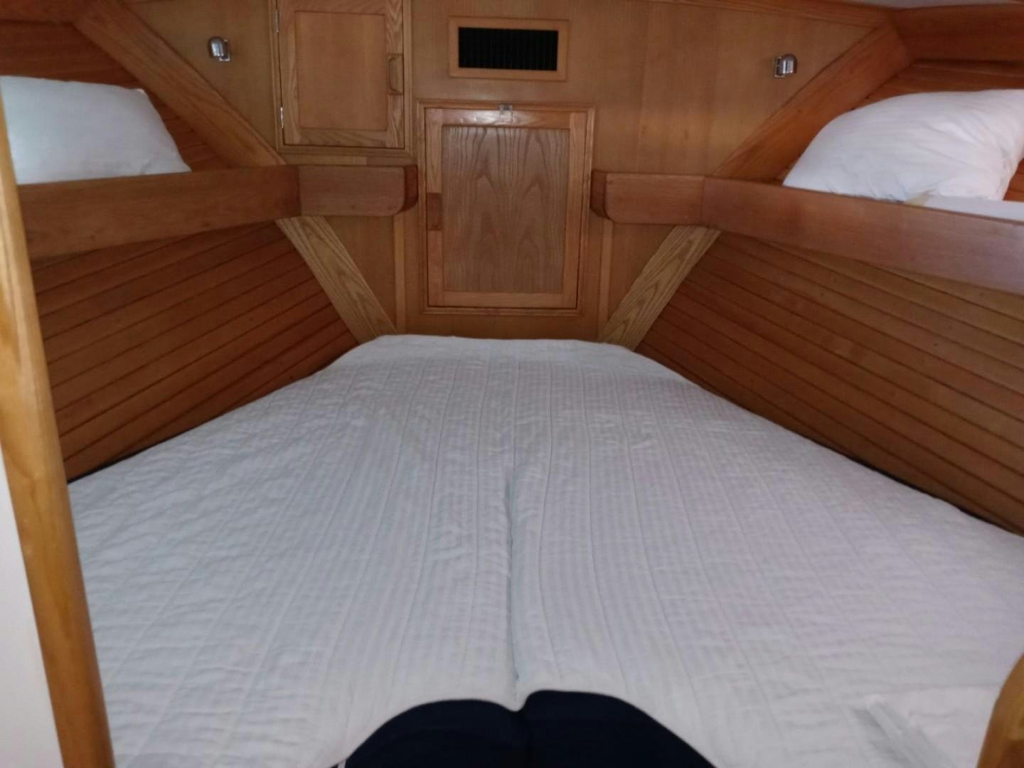 a bed with white sheets aboard DESTINATION Yacht for Sale