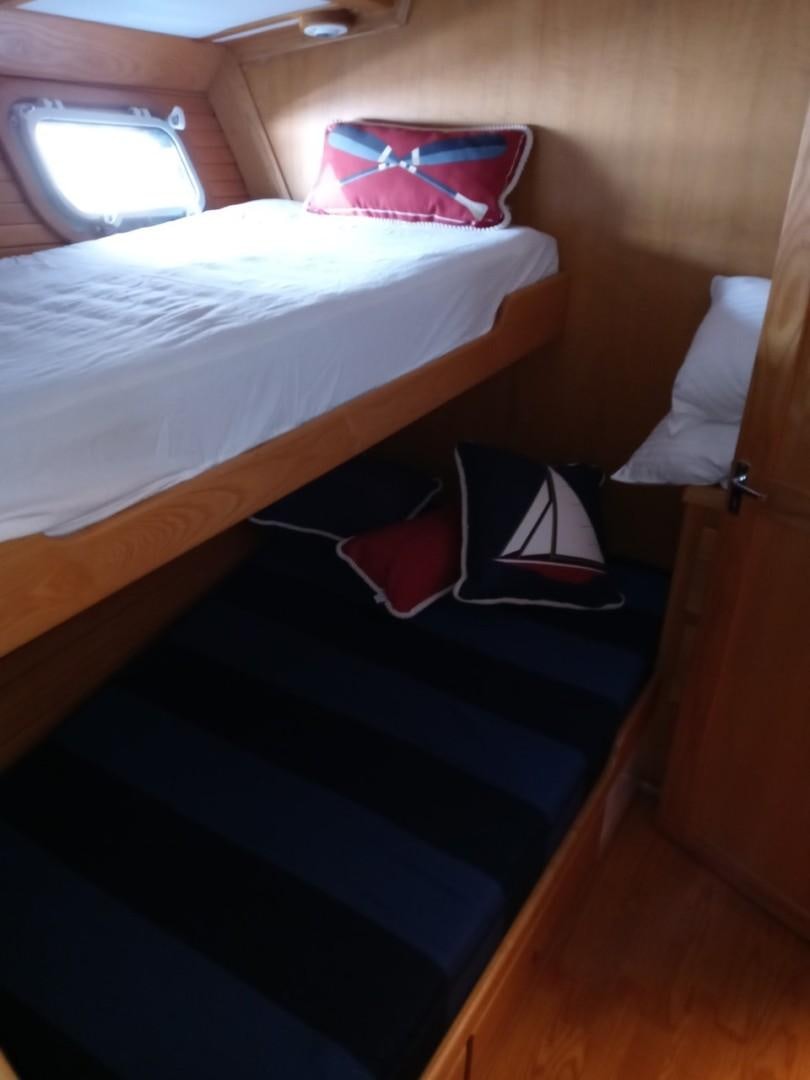 a bed with a red pillow aboard DESTINATION Yacht for Sale