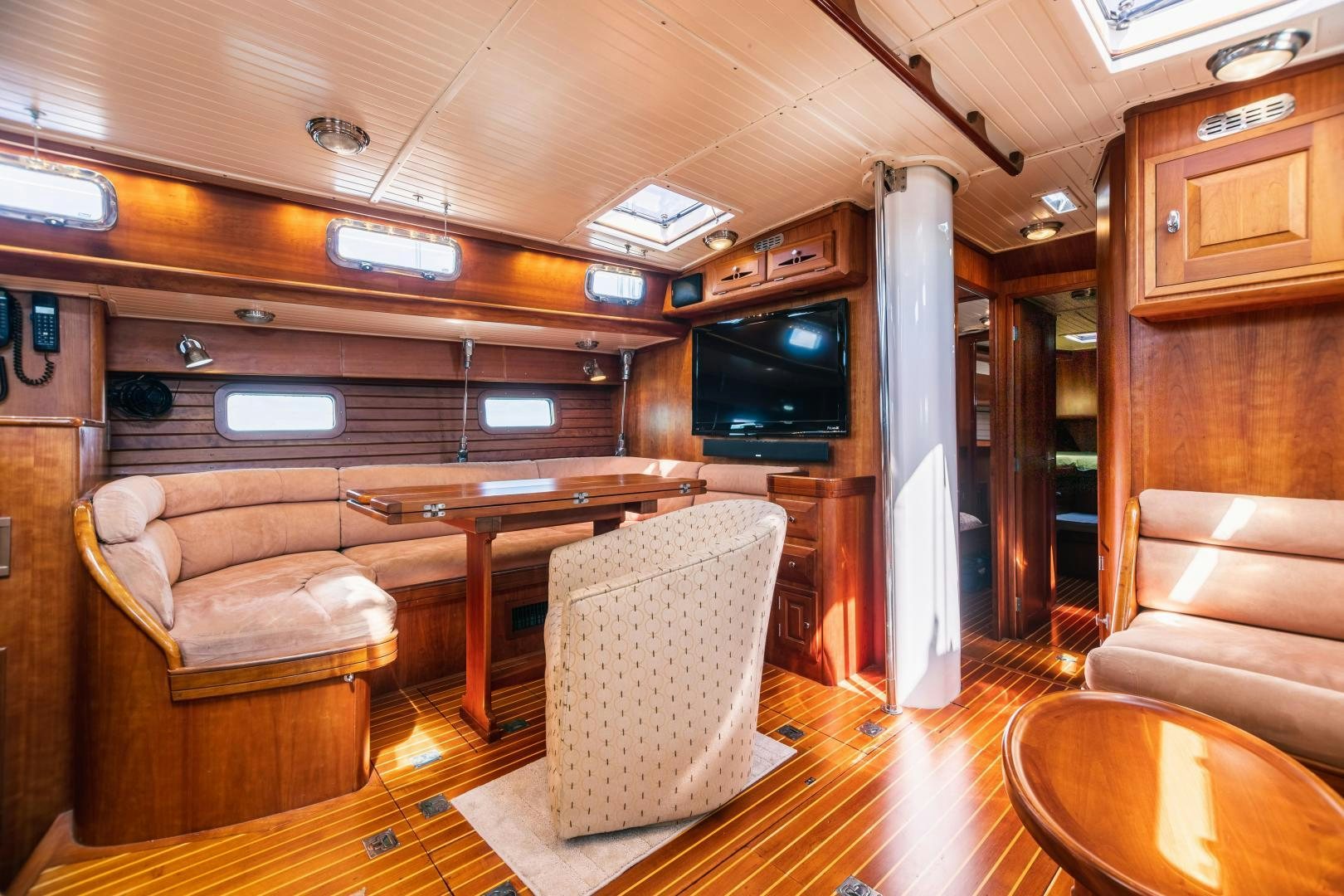 a living room with a wood table and chairs aboard SHOWTIME Yacht for Sale