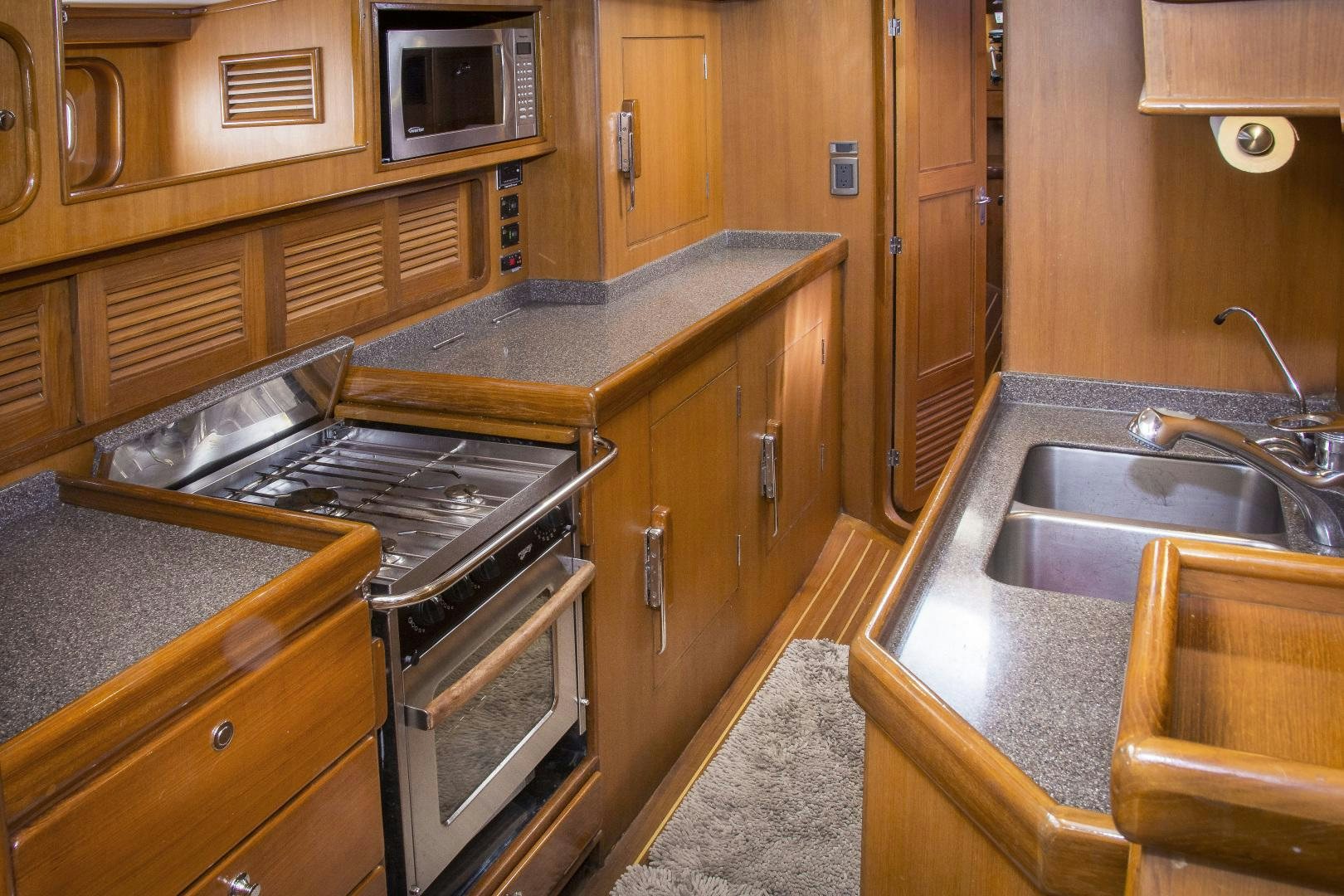a kitchen with wooden cabinets aboard REVERENCE Yacht for Sale