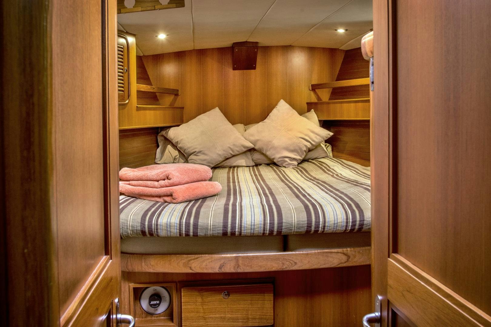 a bed with a striped sheet aboard REVERENCE Yacht for Sale