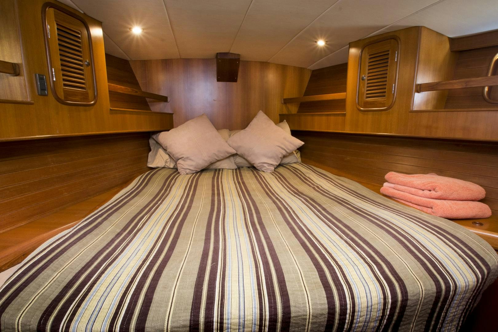 a bed with a striped sheet aboard REVERENCE Yacht for Sale
