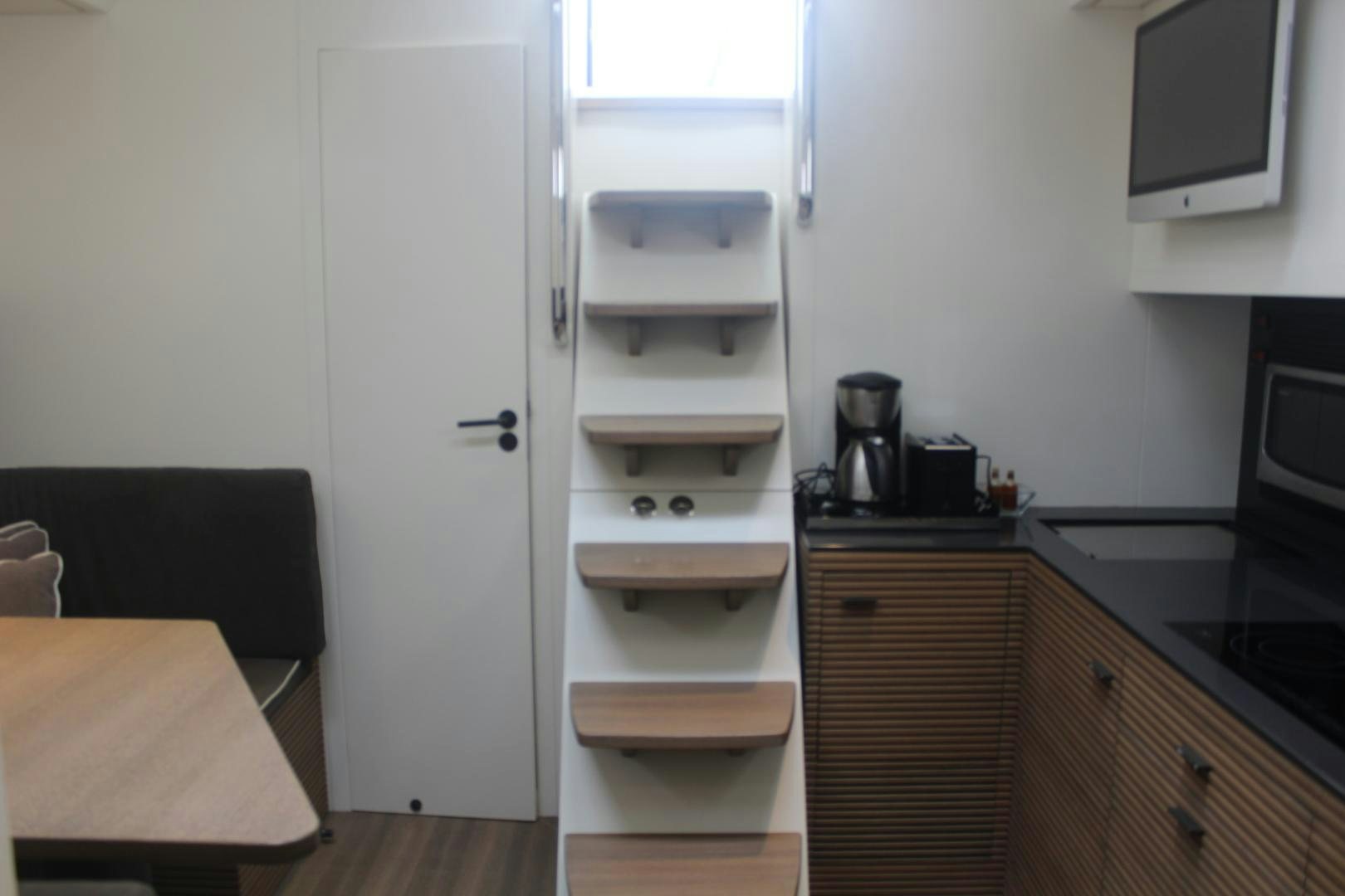 a small kitchen with a white shelf aboard FELINA Yacht for Sale