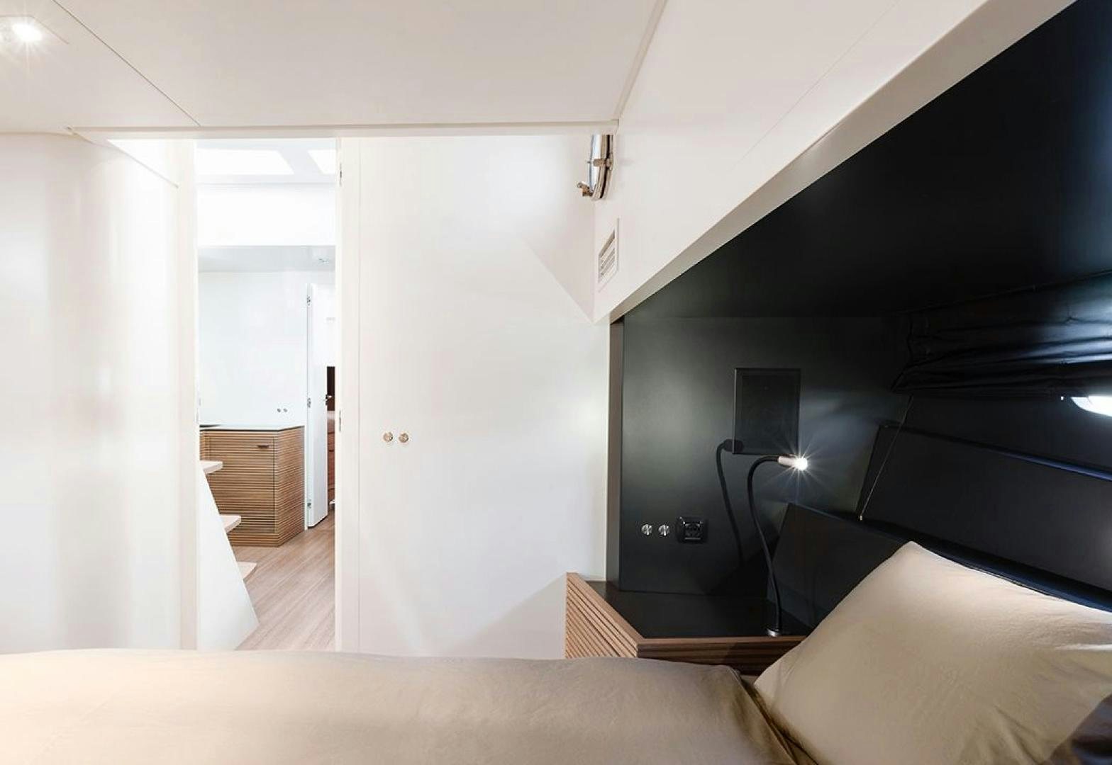 a room with a bed and a lamp aboard FELINA Yacht for Sale