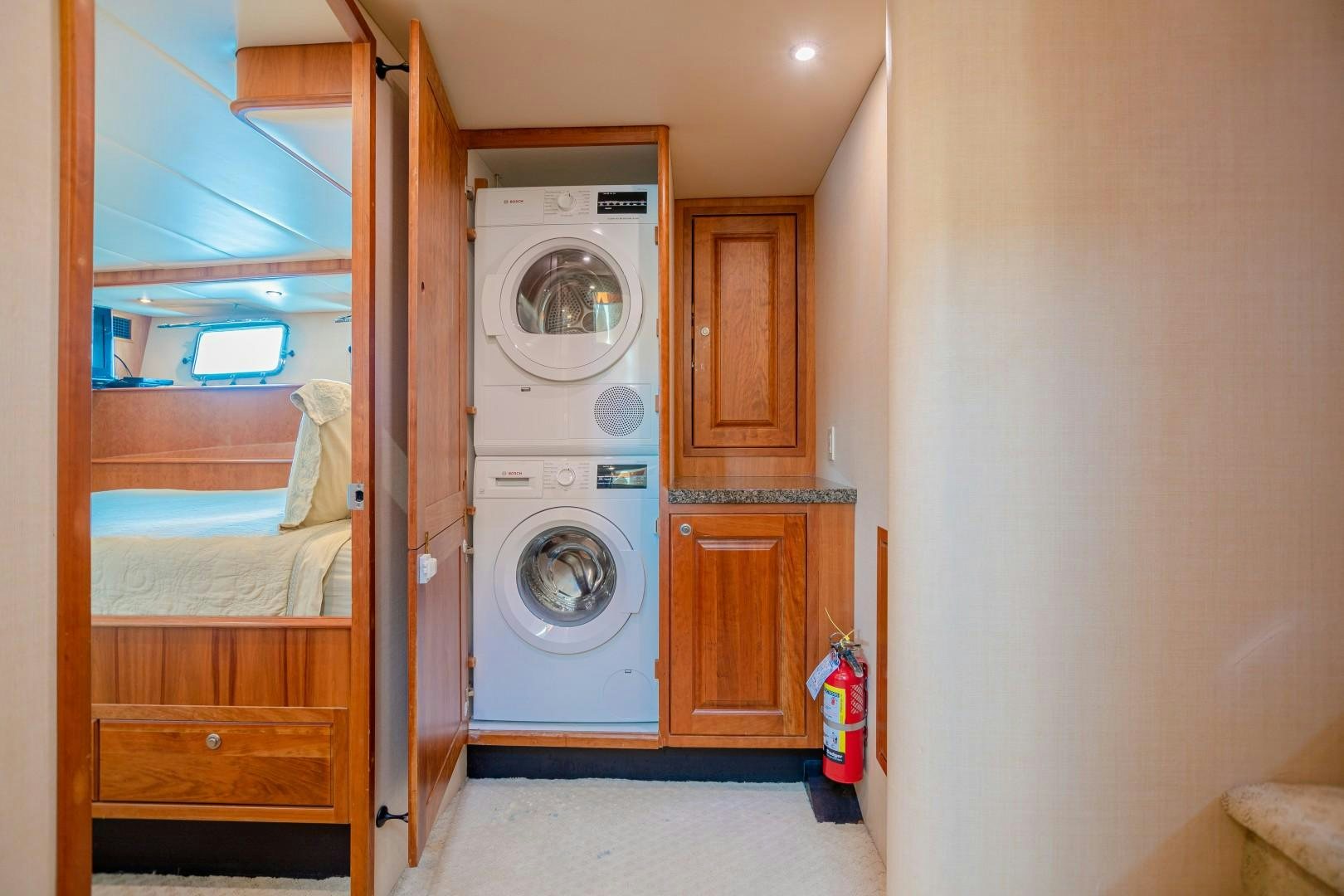 a room with a washing machine and a bed aboard NO BOUNDARIES Yacht for Sale