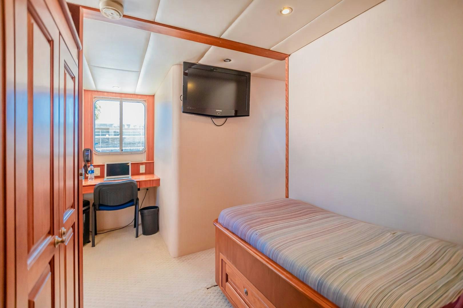 a bedroom with a bed and a television aboard NO BOUNDARIES Yacht for Sale