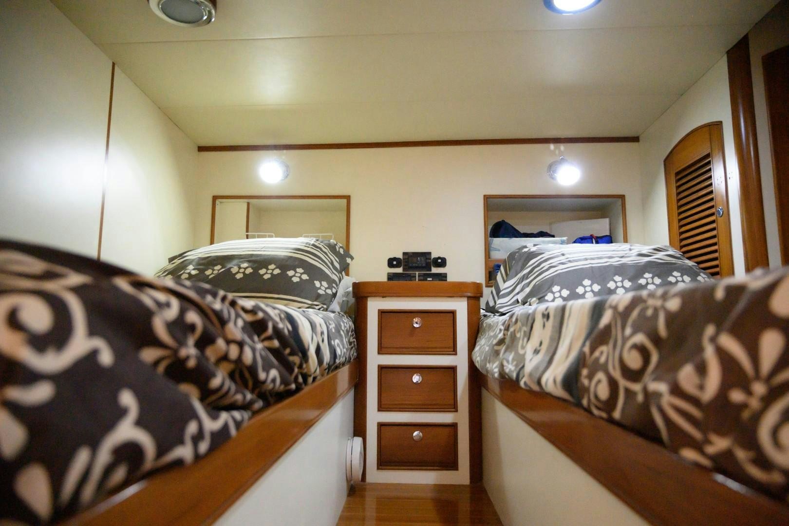 a bedroom with a bed and a dresser aboard VK Yacht for Sale