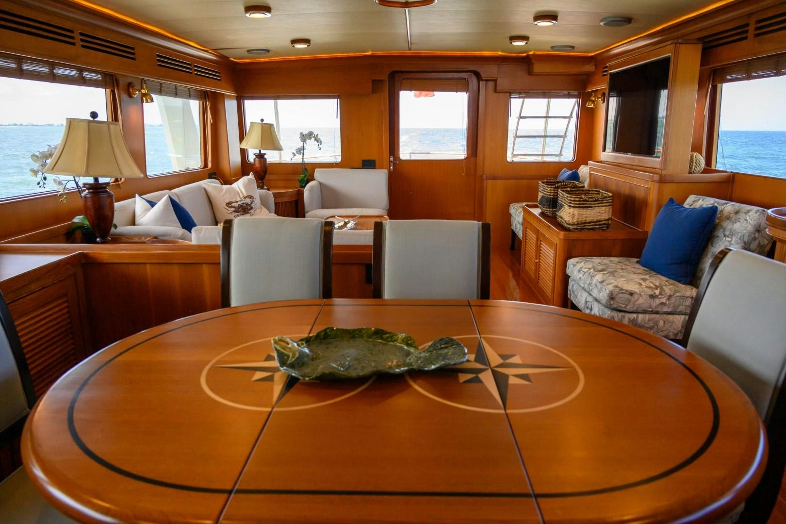 a large living room with a large table and couches aboard VK Yacht for Sale