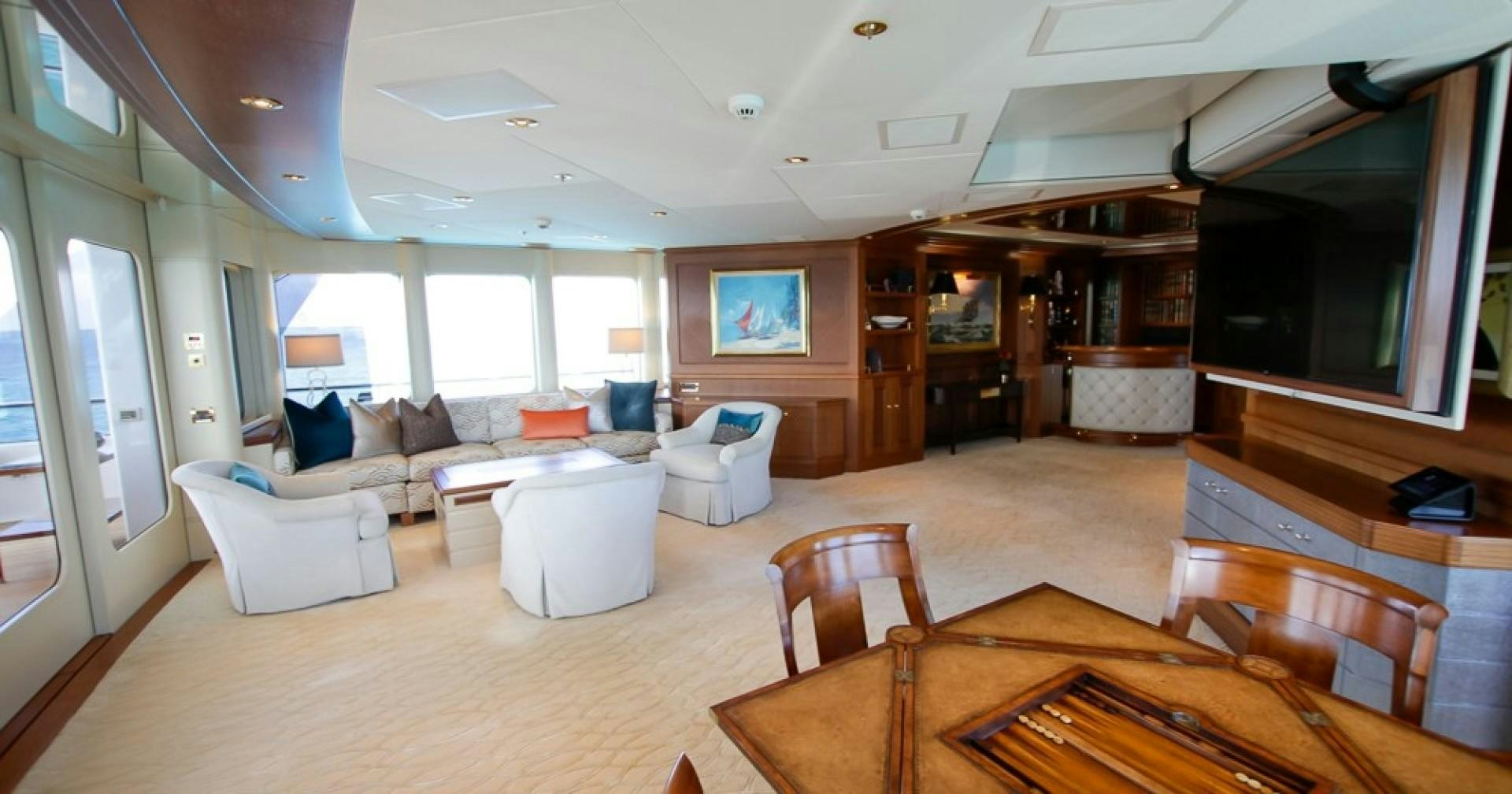 a living room with a large wood table and chairs aboard BLUE MOON Yacht for Sale
