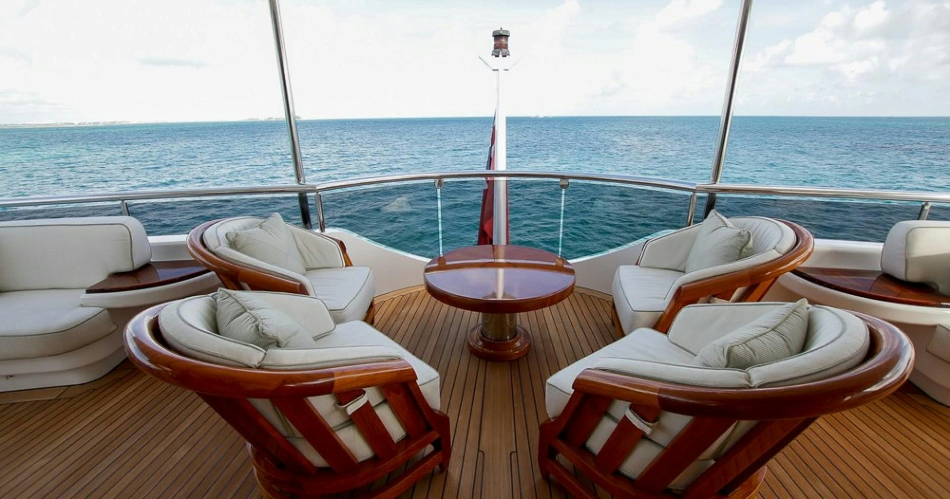 a table with chairs on it and a red pole on the side aboard BLUE MOON Yacht for Sale