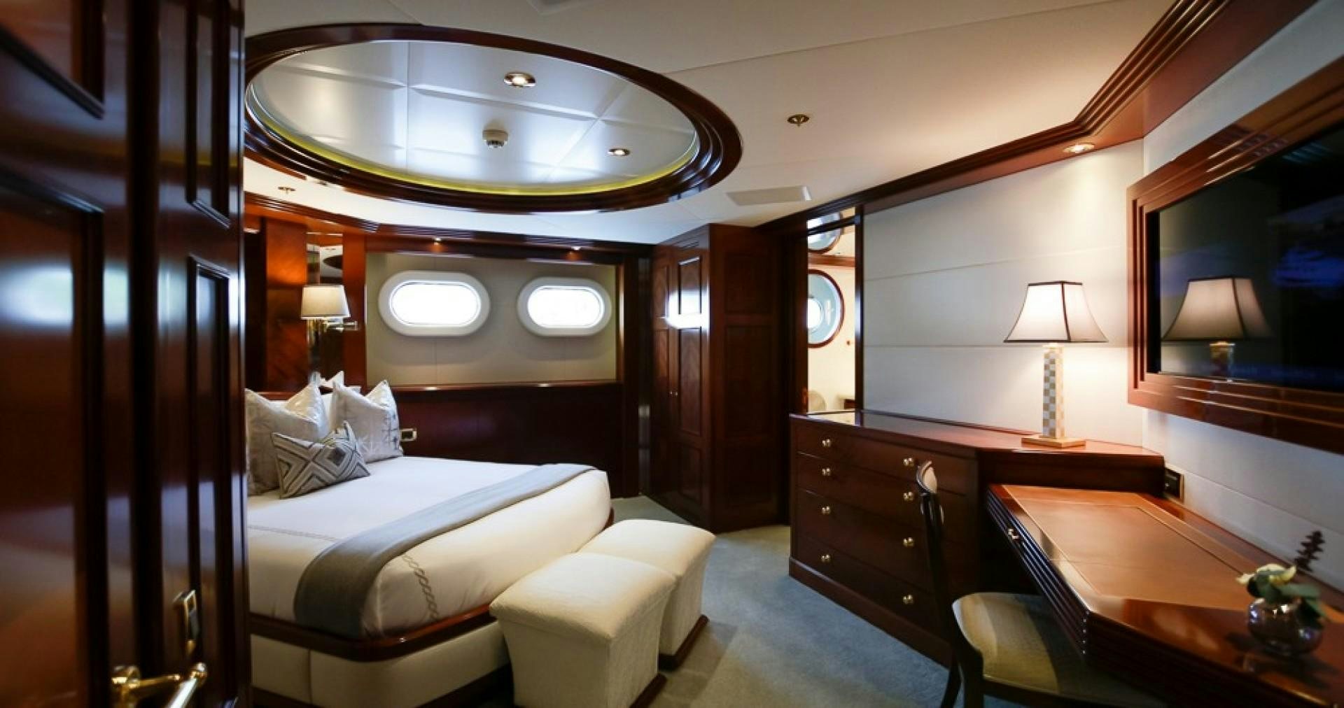 a room with a bed and desk aboard BLUE MOON Yacht for Sale