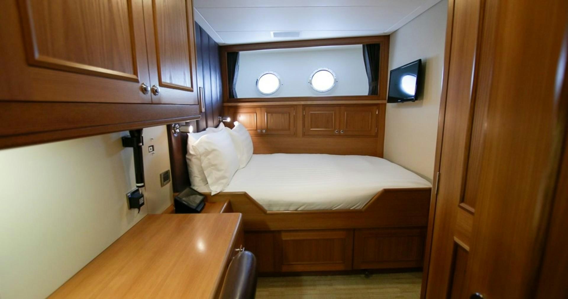 a room with a bed and a television aboard BLUE MOON Yacht for Sale