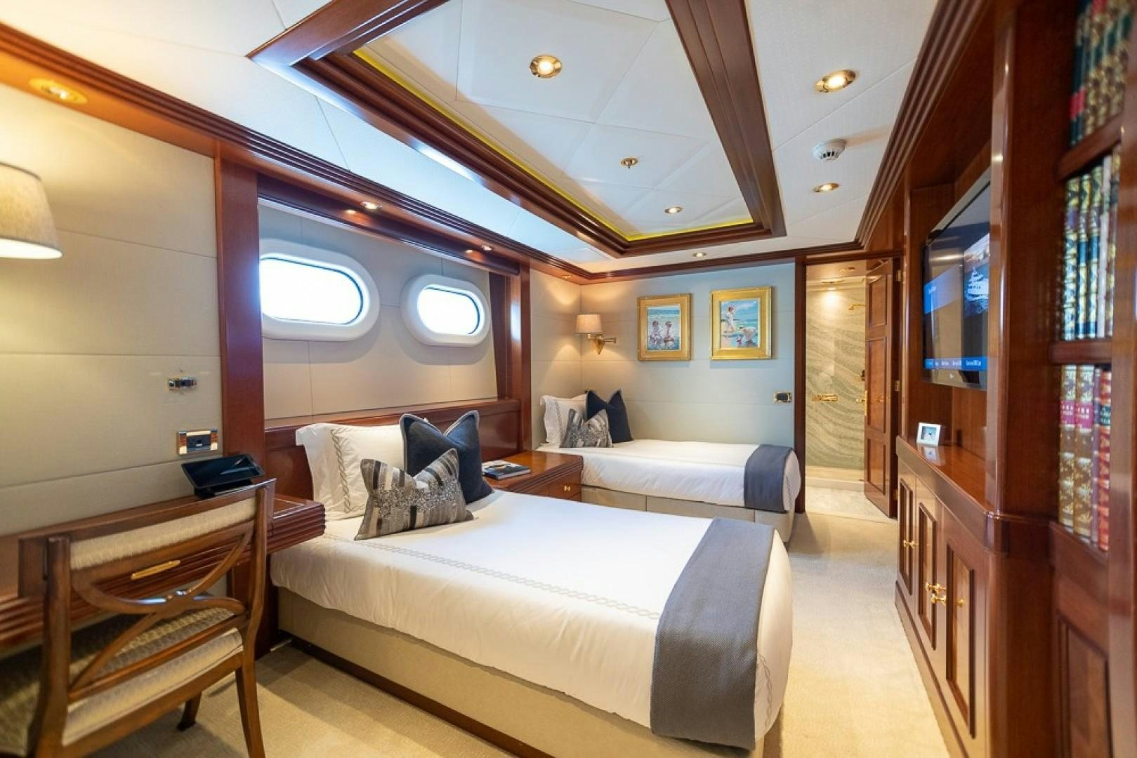 a bedroom with a bed and a desk aboard BLUE MOON Yacht for Sale
