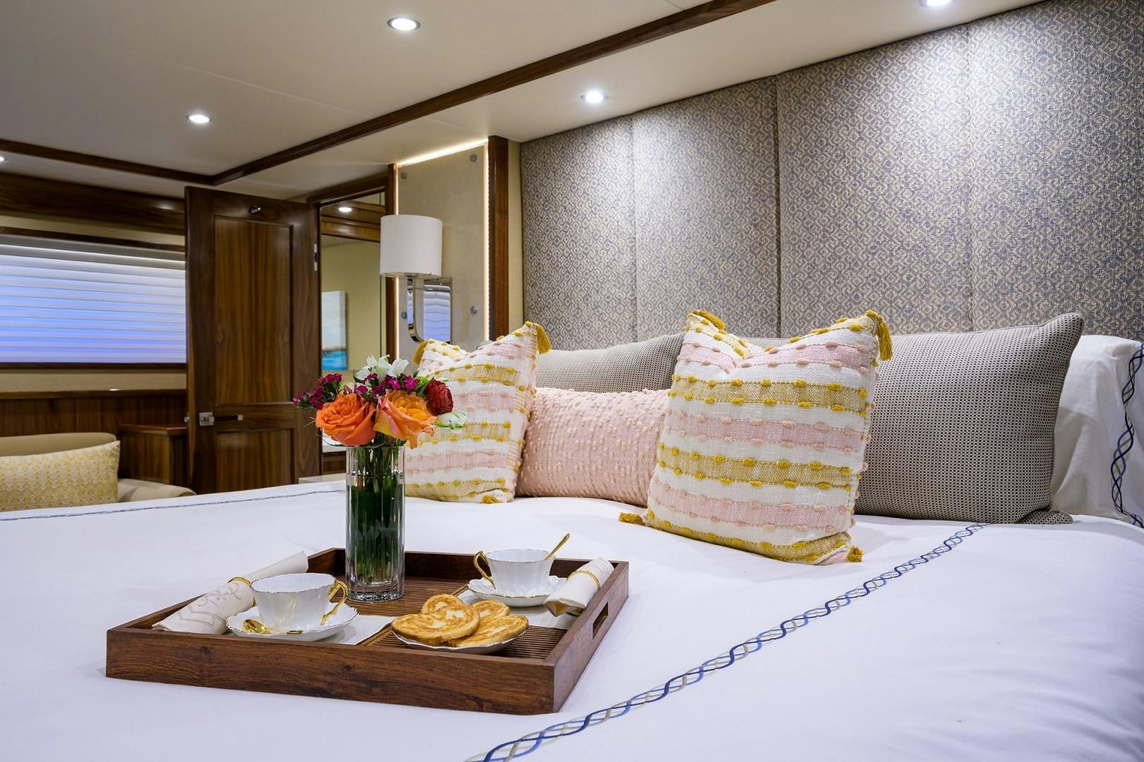 a table with a vase of flowers and a plate of food aboard NIKKI BELLA Yacht for Sale