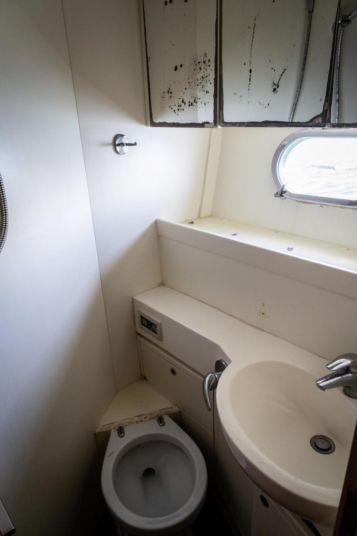 a bathroom with a toilet and sink aboard FORTIS II Yacht for Sale