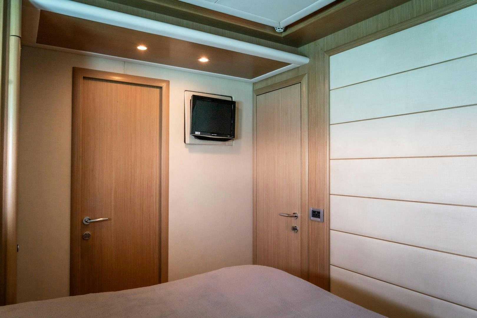 a bedroom with a television and a bed aboard FORTIS II Yacht for Sale