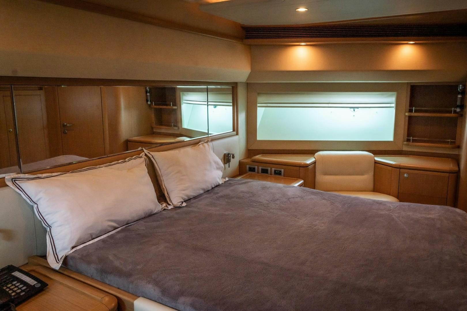 a bed with a pillow and a chair in a room aboard FORTIS II Yacht for Sale