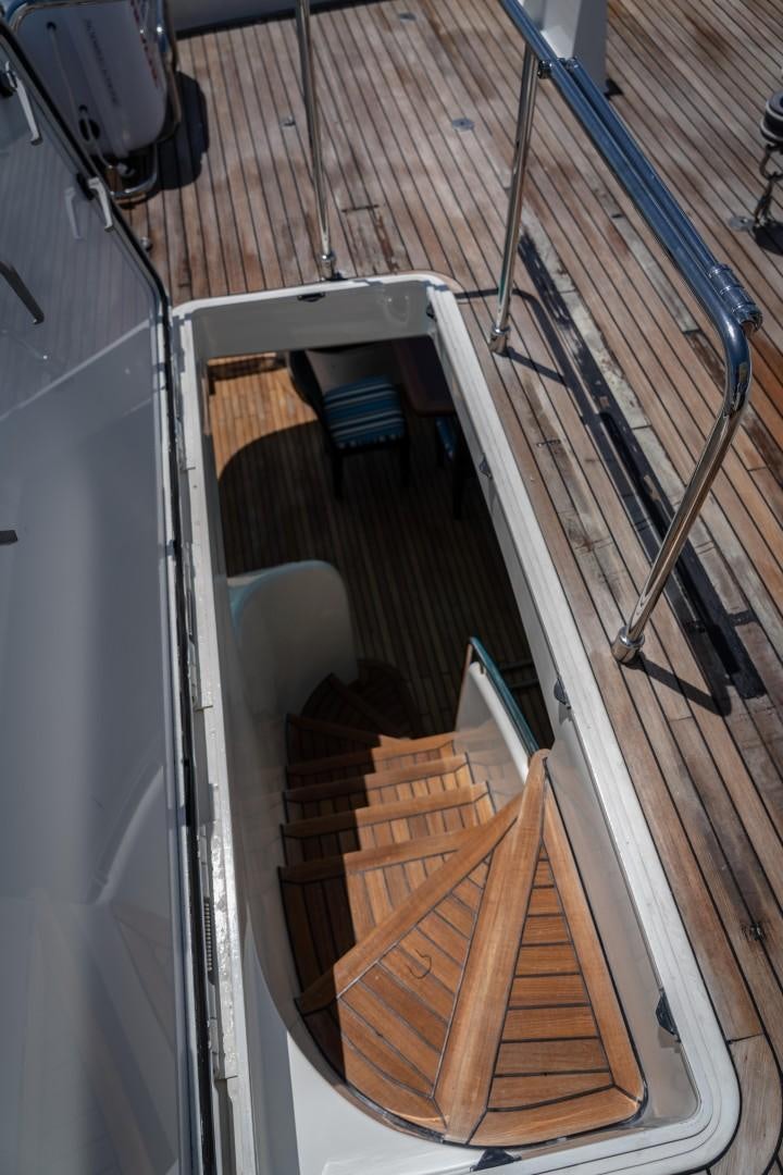 a set of stairs with a wood railing aboard FORTIS II Yacht for Sale