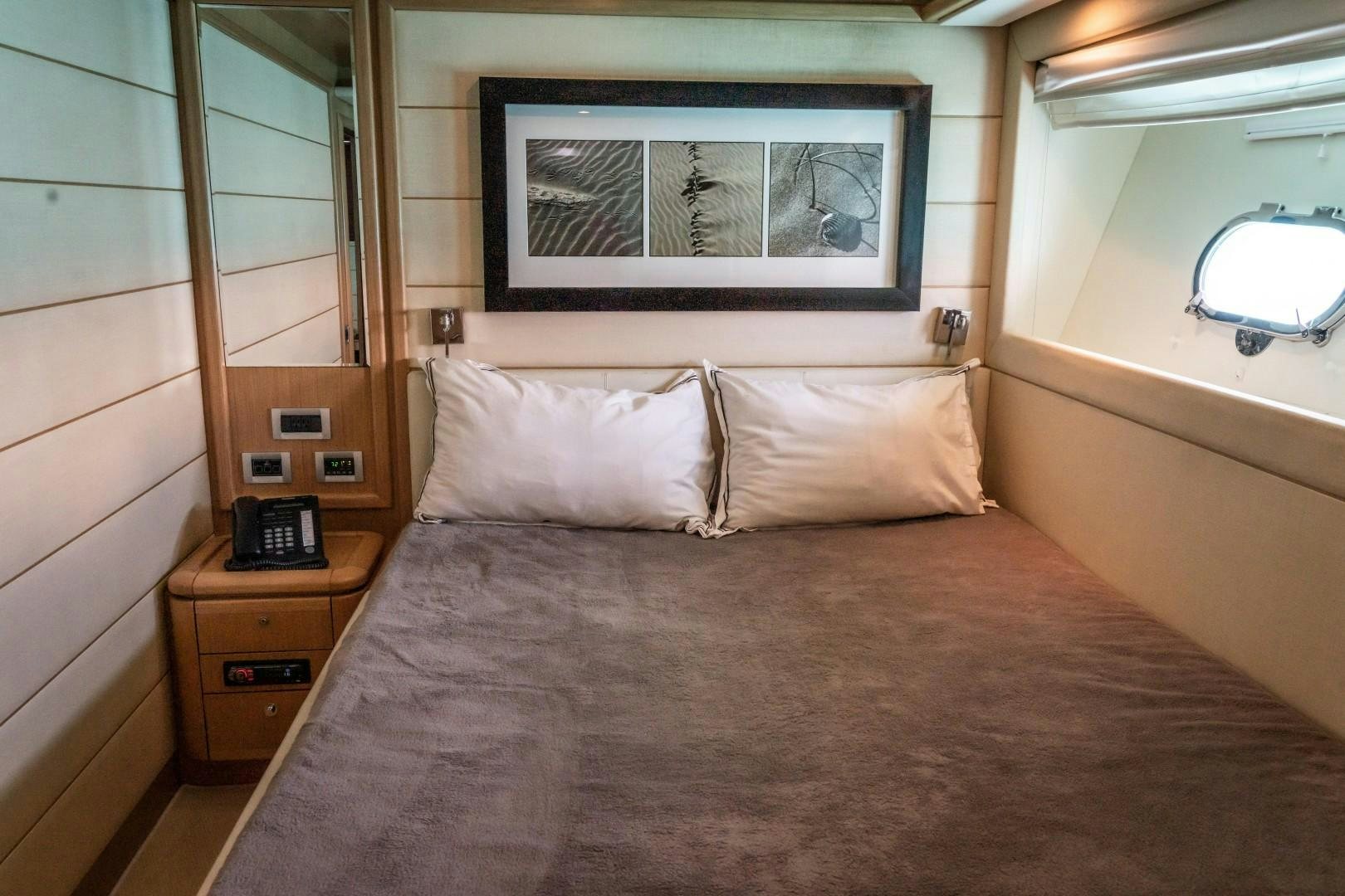 a bed with a pillow and a picture on the wall aboard FORTIS II Yacht for Sale