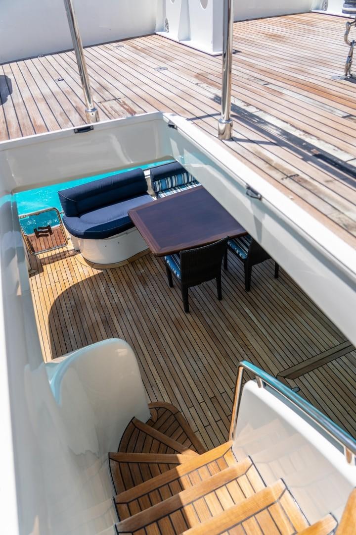 a table and chairs on a balcony aboard FORTIS II Yacht for Sale